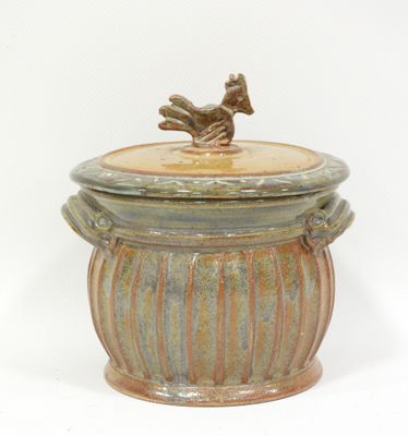a ceramic container with a bird on top
