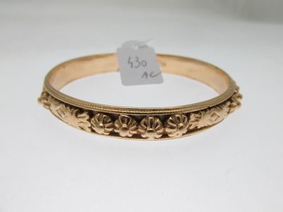 a close up of a gold bracelet with a tag on it