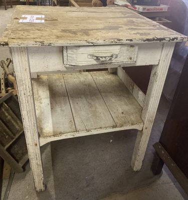 a small table with a drawer on it in a room
