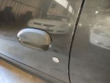 an image of a car door handle with a reflection of a car in the background