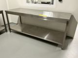 une table en acier inoxydable au milieu d'une pièce
