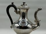 théière plaquée argent avec une poignée noire et une anse