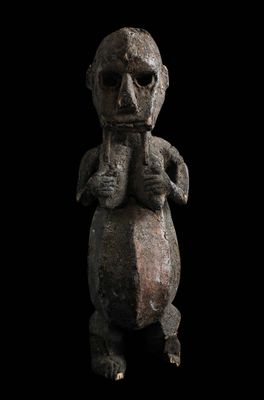 un gros plan d'une statue sur fond noir, avec un fond noir