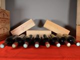 many bottles of wine sitting on a red table cloth