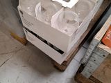 a box of empty wine glasses sitting on a pallet