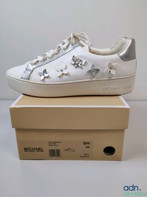 une paire de baskets blanches ornées d'étoiles argentées