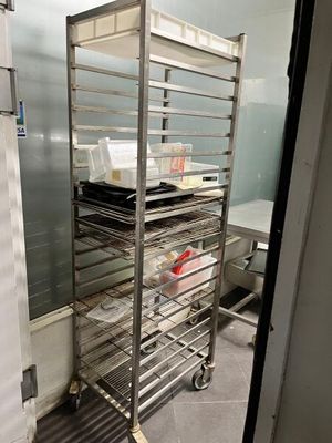 a metal rack with trays on it in a kitchen