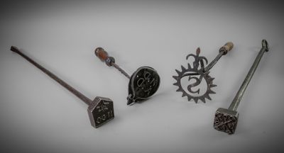 Plusieurs types d'objets métalliques sont exposés sur une surface blanche