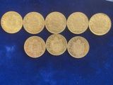 six different types of gold coins on a blue surface
