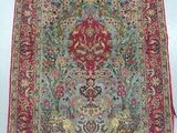 a red and blue rug with a floral design on it