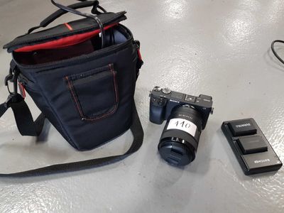 a camera, a cell phone, and a camera bag on a table