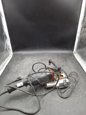 une image représentant une perceuse dans une boîte, avec un cordon d'alimentation