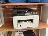 a printer sitting on top of a shelf next to a laptop
