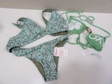 a green bikini and a green bra top on a white table