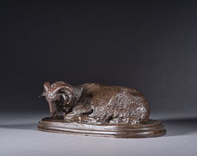 une statue représentant un mouton couché sur un socle