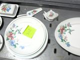 un plateau sur lequel sont posées de nombreuses assiettes, tasses et soucoupes