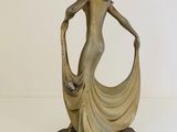 statue of a woman holding a cat on a wooden base