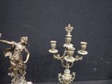 two antique bronze candlesticks on display in a glass case