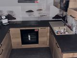 a kitchen with a black counter top and wooden cabinets