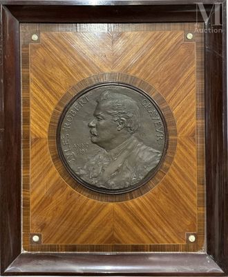 a bronze medallion of a man in a wooden frame