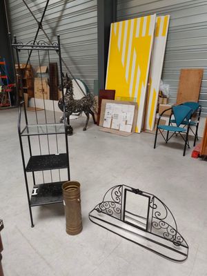 a room with a shelf, chair, chair, and other items in it