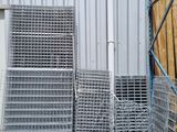 a pile of pallets sitting outside of a building next to a pile of wood