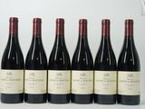 six bouteilles de vin rouge sont alignées sur une table