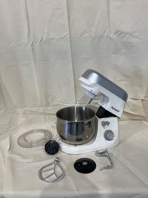 a white mixer with a metal bowl on a table