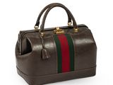 a brown leather bag with a green and red stripe on the side
