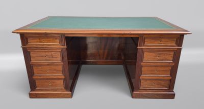 un bureau en bois avec un plateau en verre vert et des tiroirs