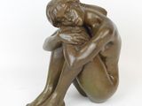 statue of a woman sitting on her knees with her hands on her knees