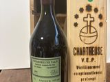 the bottle of wine is next to a wooden box on a table