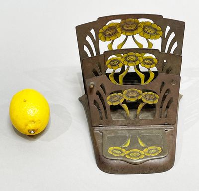 a yellow lemon sitting next to a metal holder with a mirror