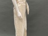 an image of a mannequin wearing a beige dress and hat