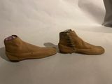pair of brown sued shoes with laces on them on a white surface