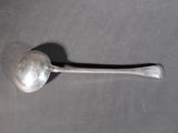 silver spoon sitting on top of a table with a black handle