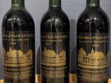 three bottles of wine sitting on top of a wooden table