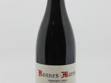 une bouteille de vin rouge posée sur une table blanche