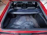 a red car with its trunk open on the street