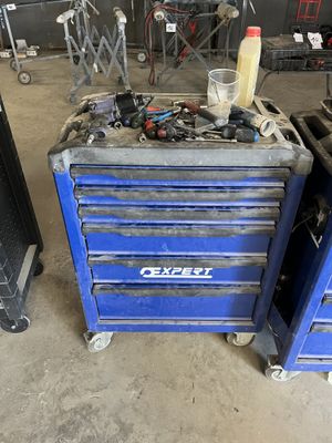 a blue tool box with tools on it in a garage