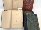 trois vieux livres posés l'un sur l'autre sur une table