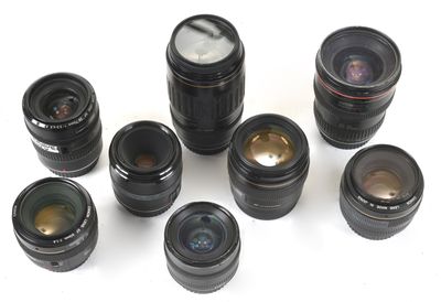 a lot of camera lenses sitting on a white surface
