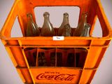 six bouteilles de Coca-Cola dans une caisse en plastique
