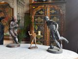 three statues of a man and a dog on a table