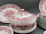 many plates and bowls that have red and white designs on them