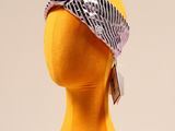 une tête de mannequin jaune coiffée d'un bandana noir et blanc