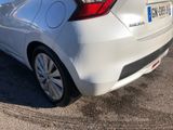 the rear end of a white car parked in a parking lot