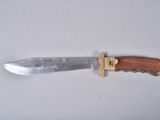 a knife with a wooden handle on a white surface