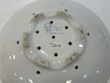 a white porcelain bowl with a hole in it