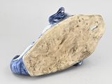 blue and white ceramic figurine of a fish on a rock